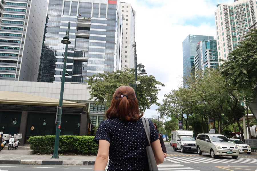 Young woman in a polka dot dress walking away from the camera in Bonifacio Global City DistrictE