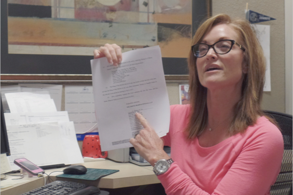 A legal secretary displaying a paper backup of a document that was recently filed